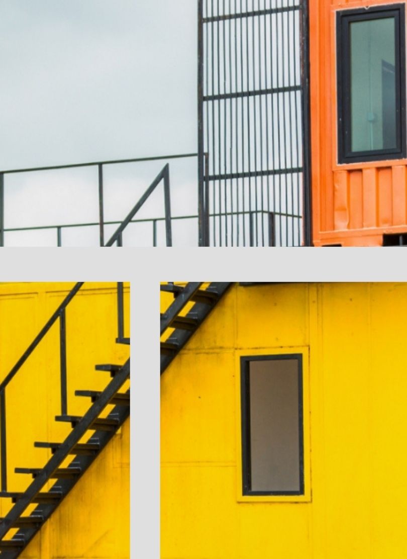 בניין בשתי קומות צהוב ואדום עם מדרגות ברזל מייצג דוגמה למבנים ניידים של חברת CONTAIN