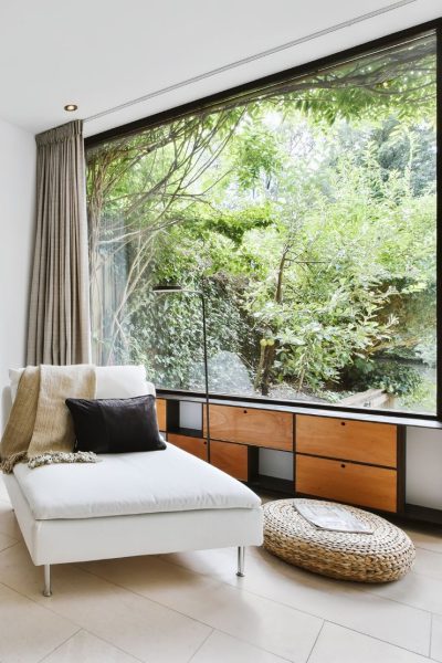 חלל עם חלון פנורמי ענק ומראה של חדר מגורים עם ספה נוחה מייצג דוגמה של קונטיינרים למגורים של חברת CONTAIN